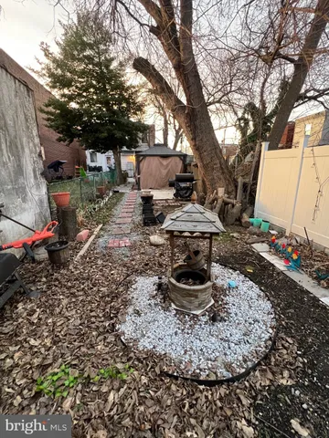 a backyard of a house with barbeque oven table and chairs