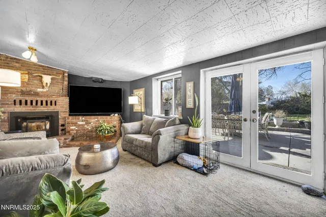 a living room with furniture a flat screen tv and a floor to ceiling window