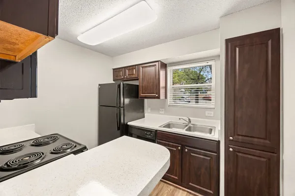 a kitchen with stainless steel appliances granite countertop a refrigerator sink and stove