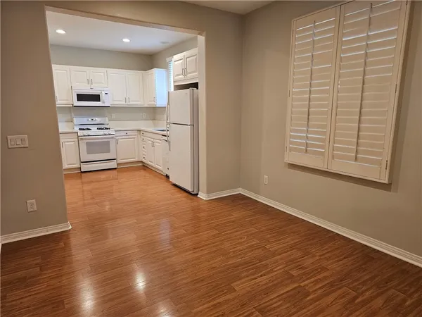 a kitchen with granite countertop wooden floors and white stainless steel appliances