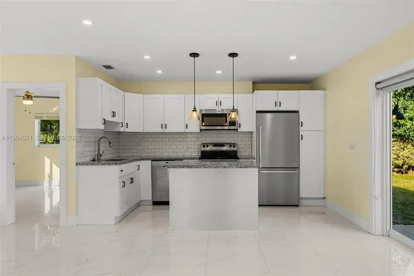 a kitchen with stainless steel appliances granite countertop a refrigerator a stove a sink and a refrigerator