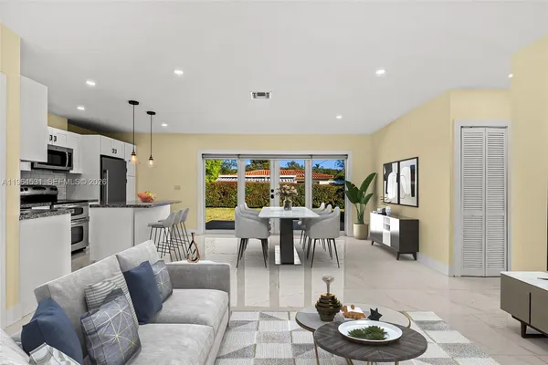 a living room with furniture kitchen view and a refrigerator