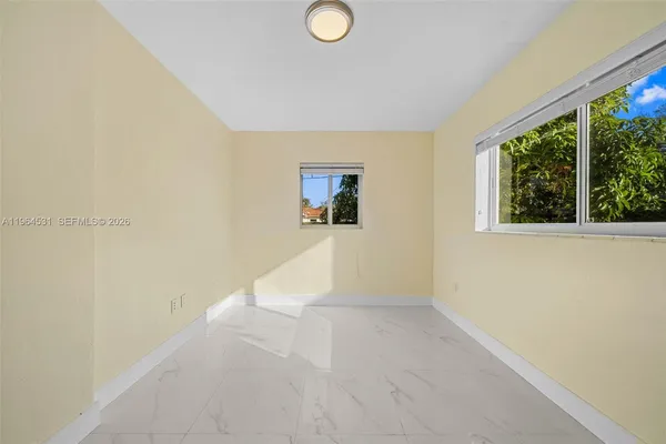 a view of a livingroom with wooden floor and a large window