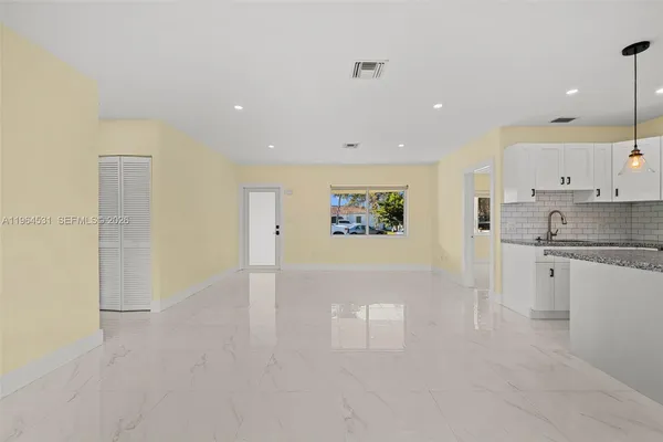 a view of kitchen with a sink a refrigerator and window