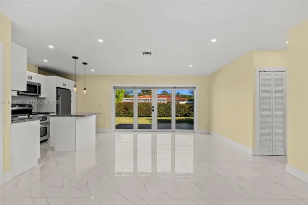 a view of kitchen with stainless steel appliances with white cabinets