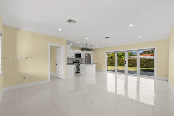 a view of empty room with wooden floor and windows