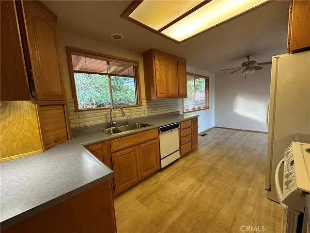 a kitchen with stainless steel appliances granite countertop a sink a stove and a refrigerator