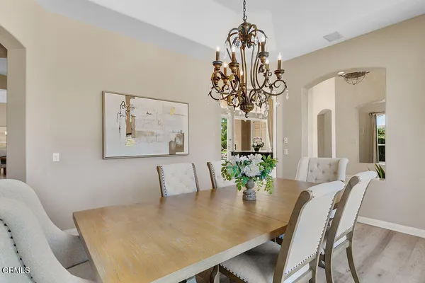 a dining room with furniture a chandelier and wooden floor