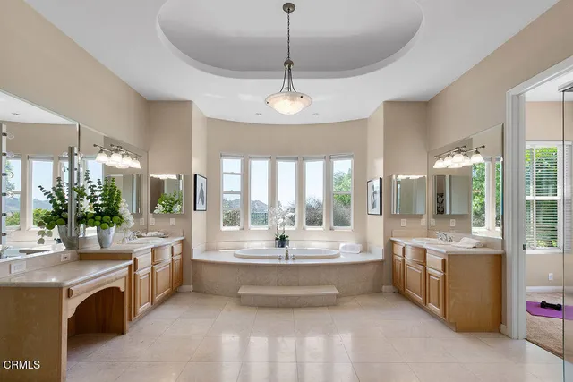 a front view of a house with a yard and potted plants