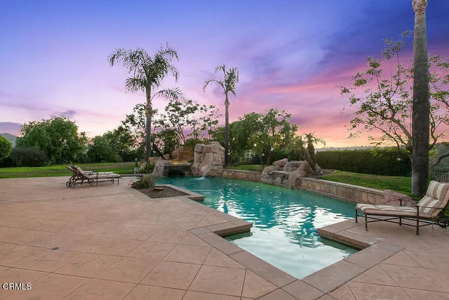 a white house with a large tree in the background