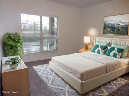 a bedroom with a large bed and a window