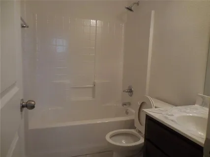 a bathroom with a granite countertop sink toilet and bathtub