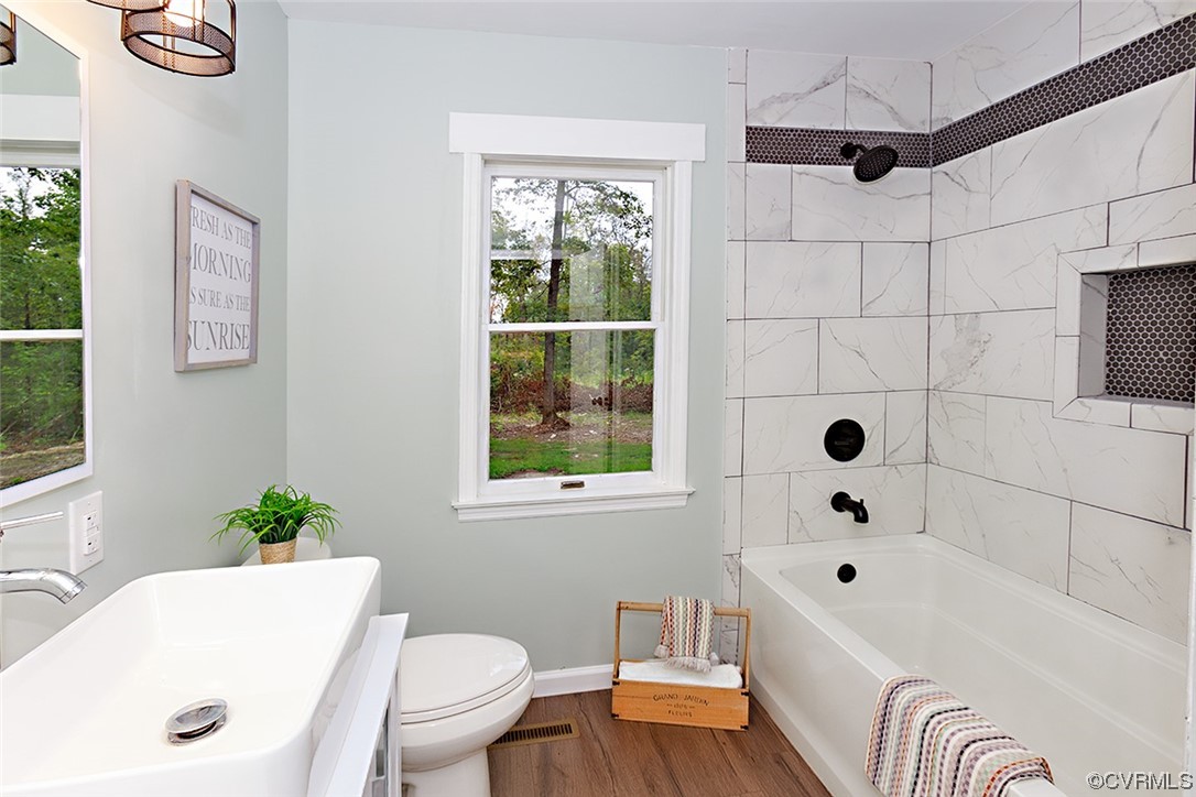 674 Spring Grove Road Spring Grove, VA 23881 - Photo 22 of 37 a bathroom with a bathtub a sink a window and a shower