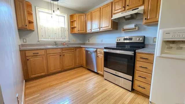 a kitchen with stainless steel appliances granite countertop a stove and a sink