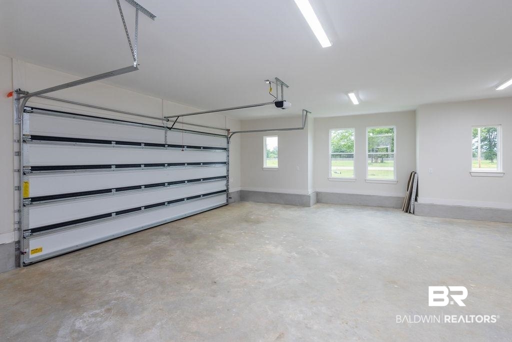 13066 Gopher Court Elberta, AL 36530 - Photo 21 of 38 Spacious garage with a concrete floor, bright overhead fluorescent lighting, and a wide segmented garage door with an automatic opener