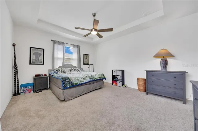 a spacious bedroom with a bed and a chandelier