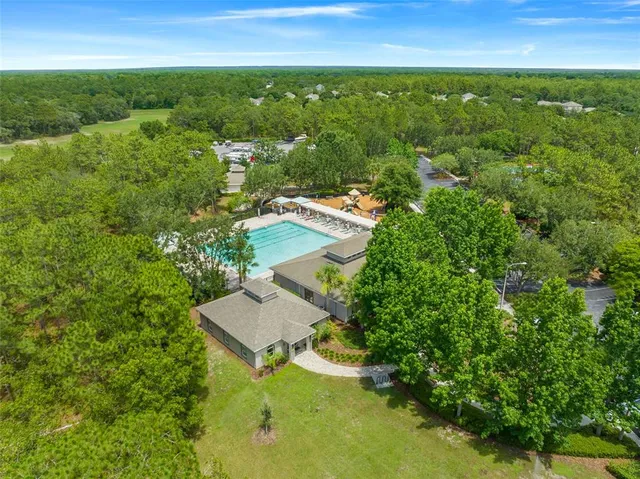 an aerial view of residential houses with outdoor space and trees