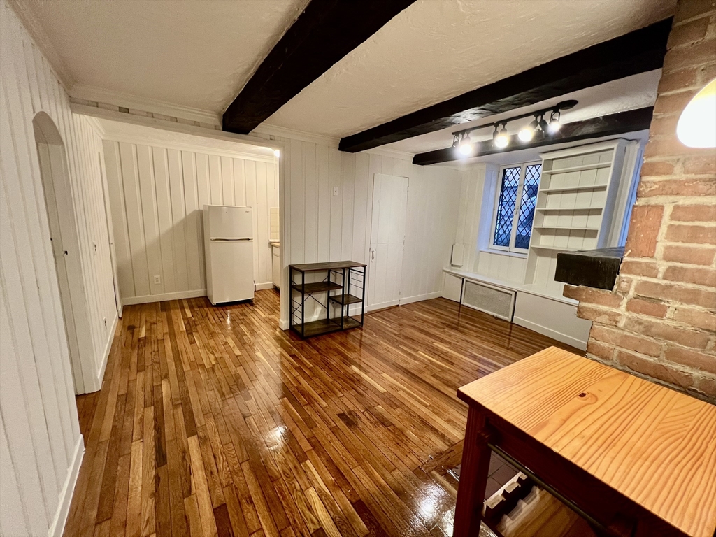 101 Myrtle Street, Unit A Boston, MA 02114 - Photo 3 of 15 a living room with a bed furniture and a window