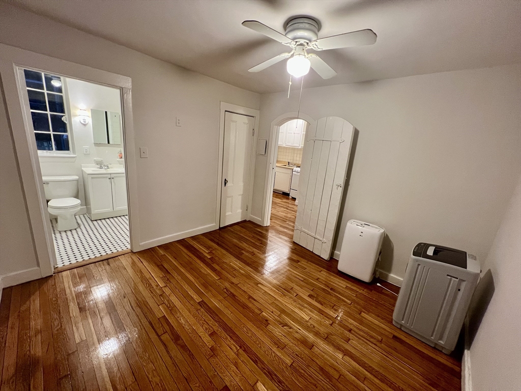 101 Myrtle Street, Unit A Boston, MA 02114 - Photo 9 of 15 wooden floor in an empty room with a window