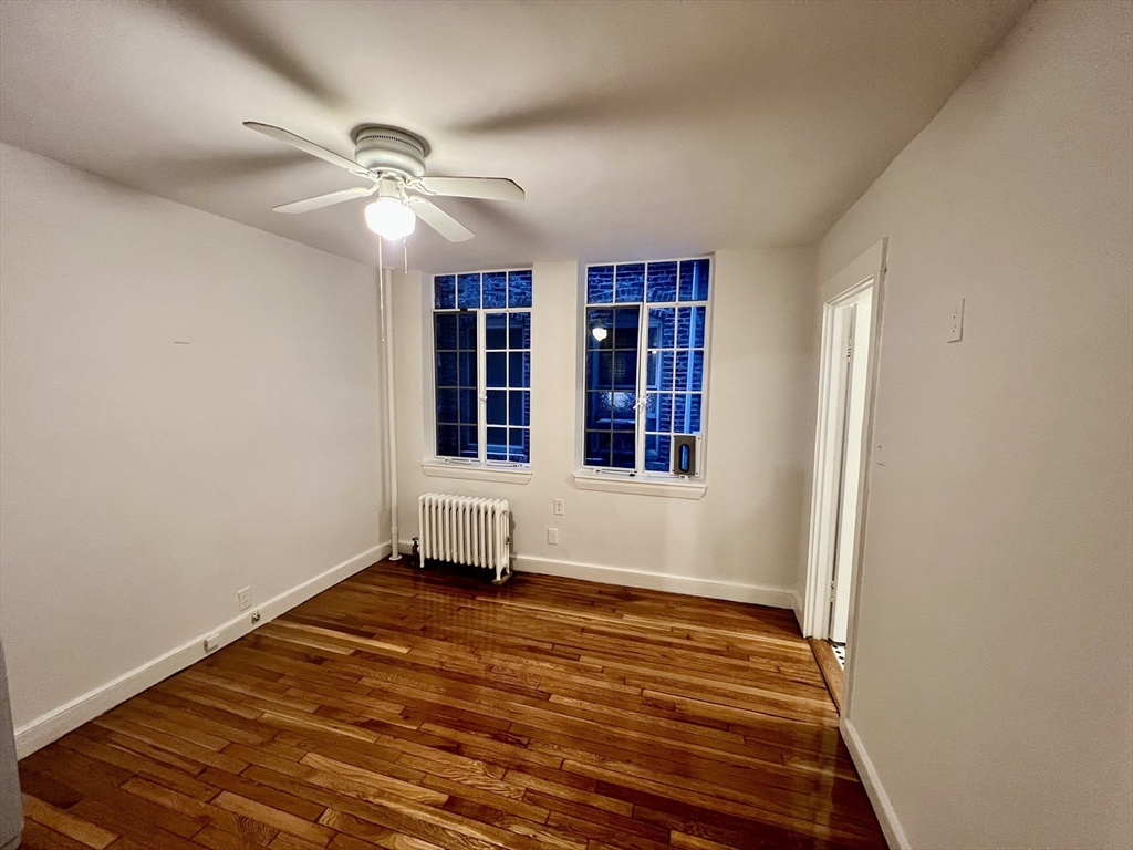 101 Myrtle Street, Unit A Boston, MA 02114 - Photo 10 of 15 wooden floor in an empty room with a window