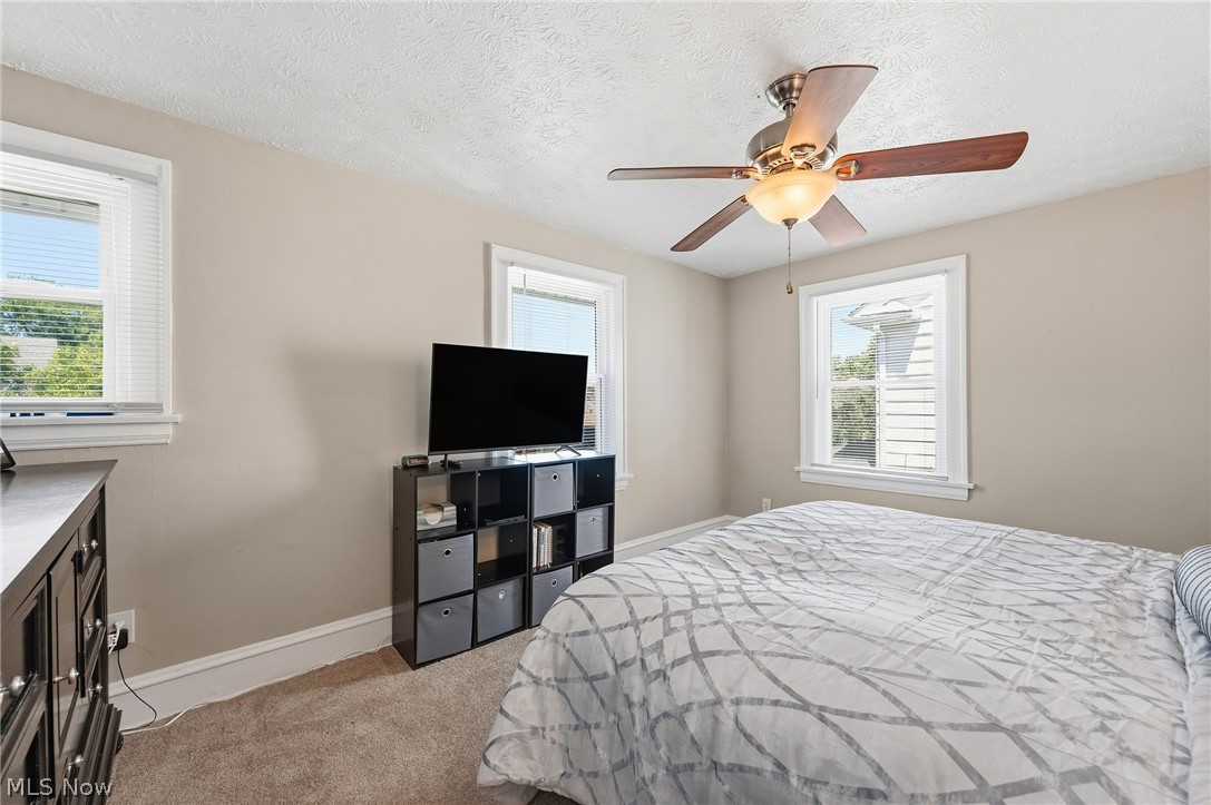 3386 Sylvanhurst Road Cleveland Heights, OH 44112 - Photo 19 of 46 Carpeted room featuring a ceiling fan with light fixture, two windows with blinds, and neutral wall tones