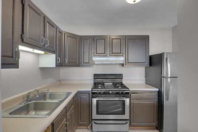 a kitchen with stainless steel appliances granite countertop a sink stove and refrigerator