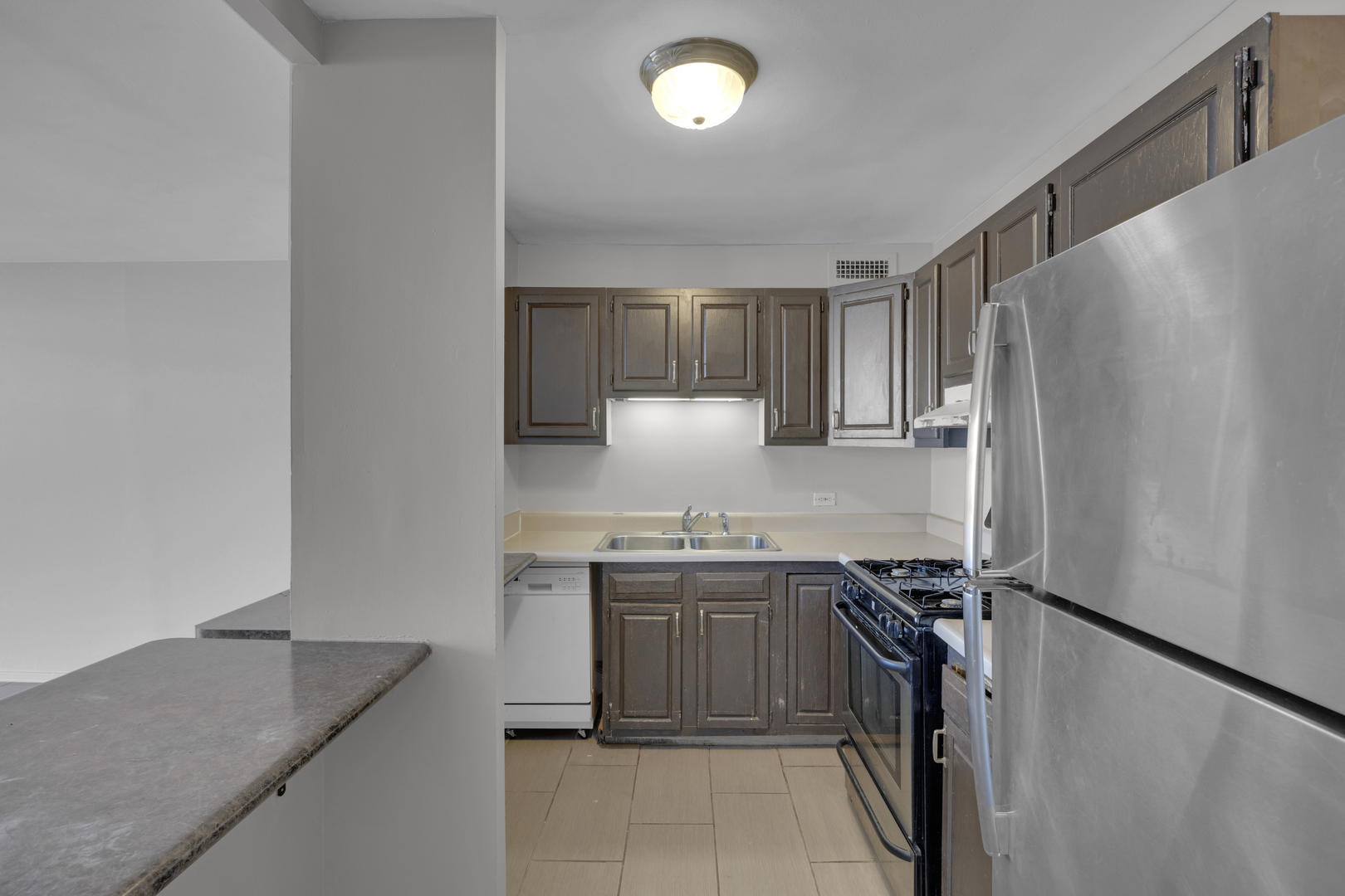 2901 South Michigan Avenue, Unit 908 Chicago, IL 60616 - Photo 14 of 22 a kitchen with stainless steel appliances granite countertop a sink stove and refrigerator
