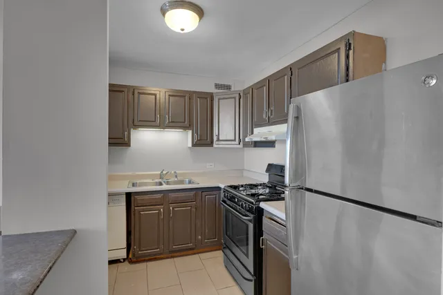 a kitchen with stainless steel appliances a refrigerator sink and stove