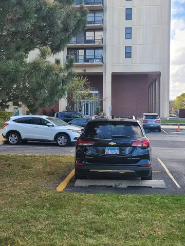 a front view of a house with a garden and car parked