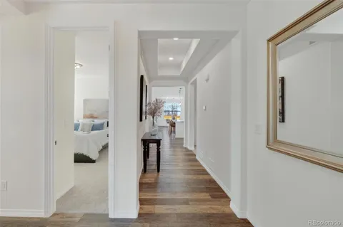 a view of a hallway with wooden floor and staircase