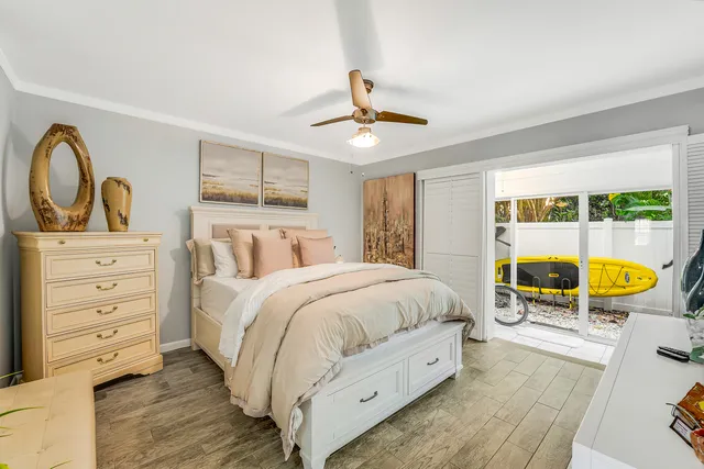 a bedroom with a bed a dresser and next to a window