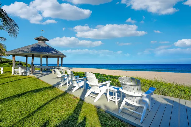 a view of a swimming pool with lawn chairs under an umbrella