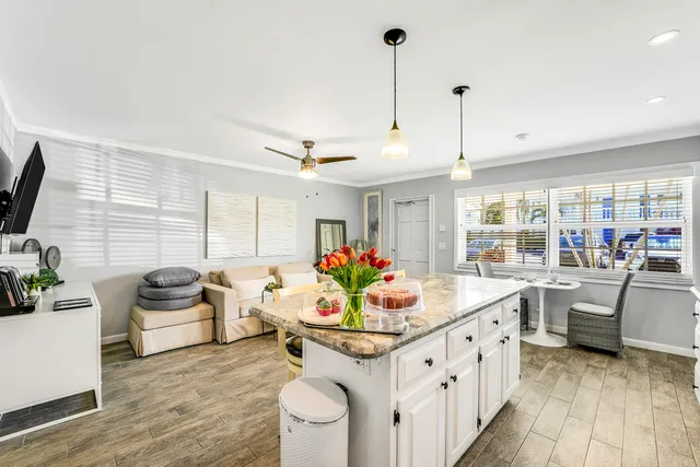 a kitchen with granite countertop a stove and white cabinets