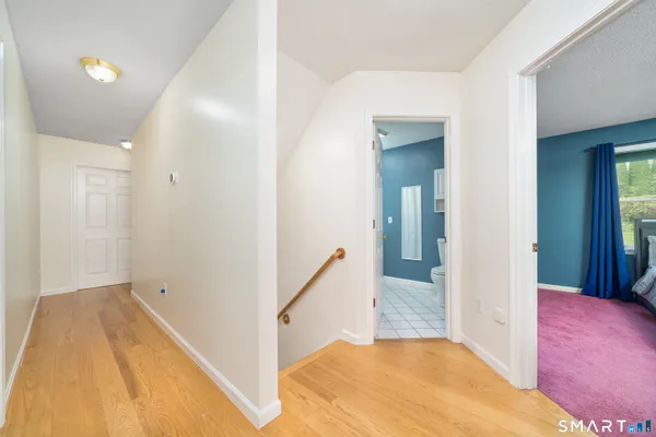 a view of a hallway with wooden floor and staircase