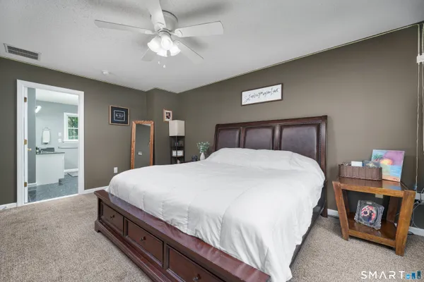 a bedroom with a large bed and a chandelier