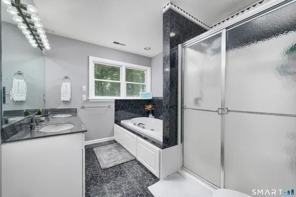 a bathroom with a tub sink and mirror