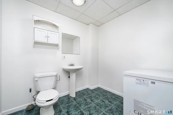 a bathroom with a sink a toilet and a mirror