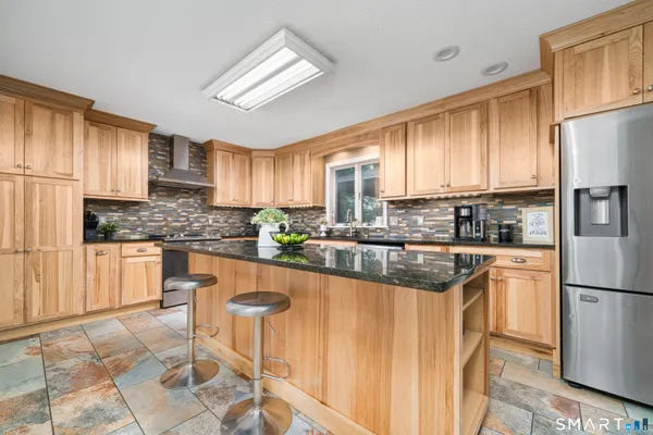 a kitchen with granite countertop a refrigerator stove top oven and sink
