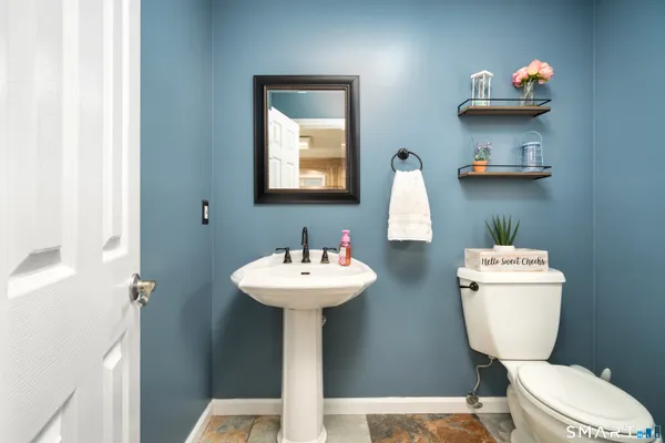 a bathroom with a toilet sink and mirror