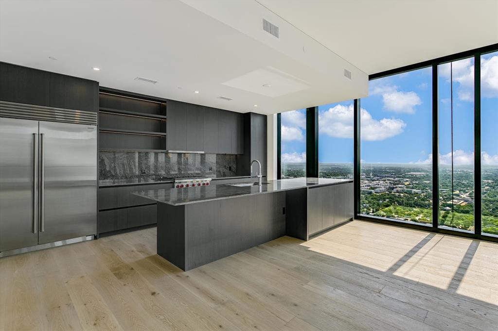 610 Davis Street, Unit 4201 Austin, TX 78701 - Photo 2 of 40 Kitchen featuring floor to ceiling windows, modern cabinets, stainless steel built in refrigerator, open shelves, and backsplash