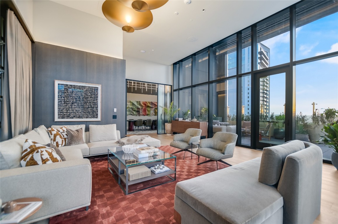610 Davis Street, Unit 4201 Austin, TX 78701 - Photo 23 of 40 Living room featuring a high ceiling, floor to ceiling windows, and wood finished floors