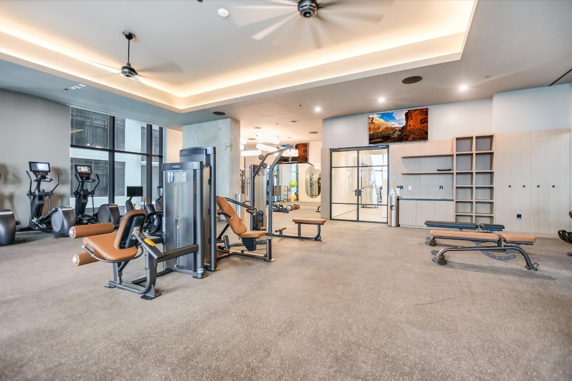 610 Davis Street, Unit 4201 Austin, TX 78701 - Photo 31 of 40 Workout area with a tray ceiling, ceiling fan, recessed lighting, carpet flooring, and floor to ceiling windows