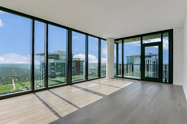 a living room with large windows and furniture