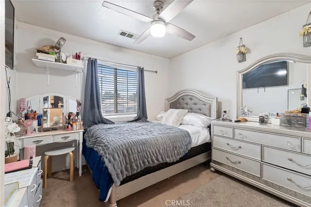 a bedroom with a bed and a large mirror with the dresser