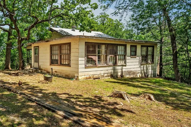 a backyard of a house with yard table and chairs