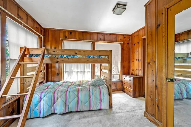 a bedroom with a bed and a large window