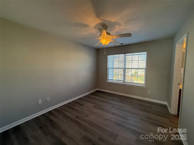 an empty room with windows and wooden floor