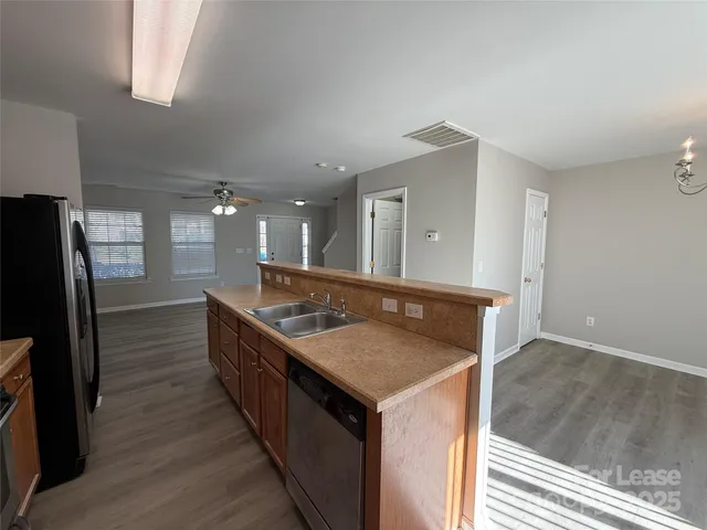 a kitchen with kitchen island a sink stove and refrigerator