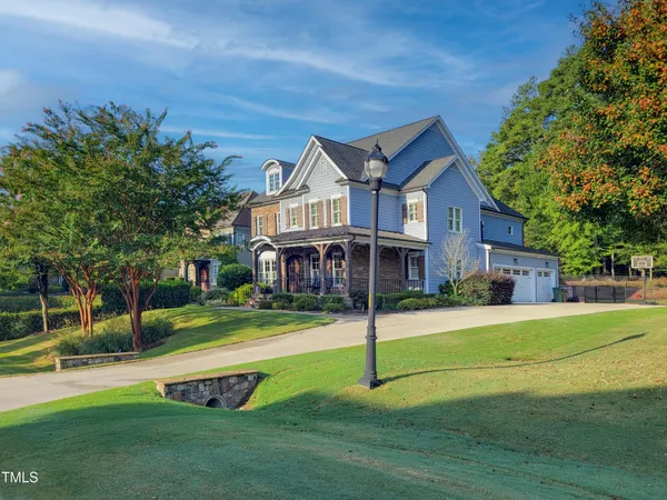 a front view of a house with a yard and tree