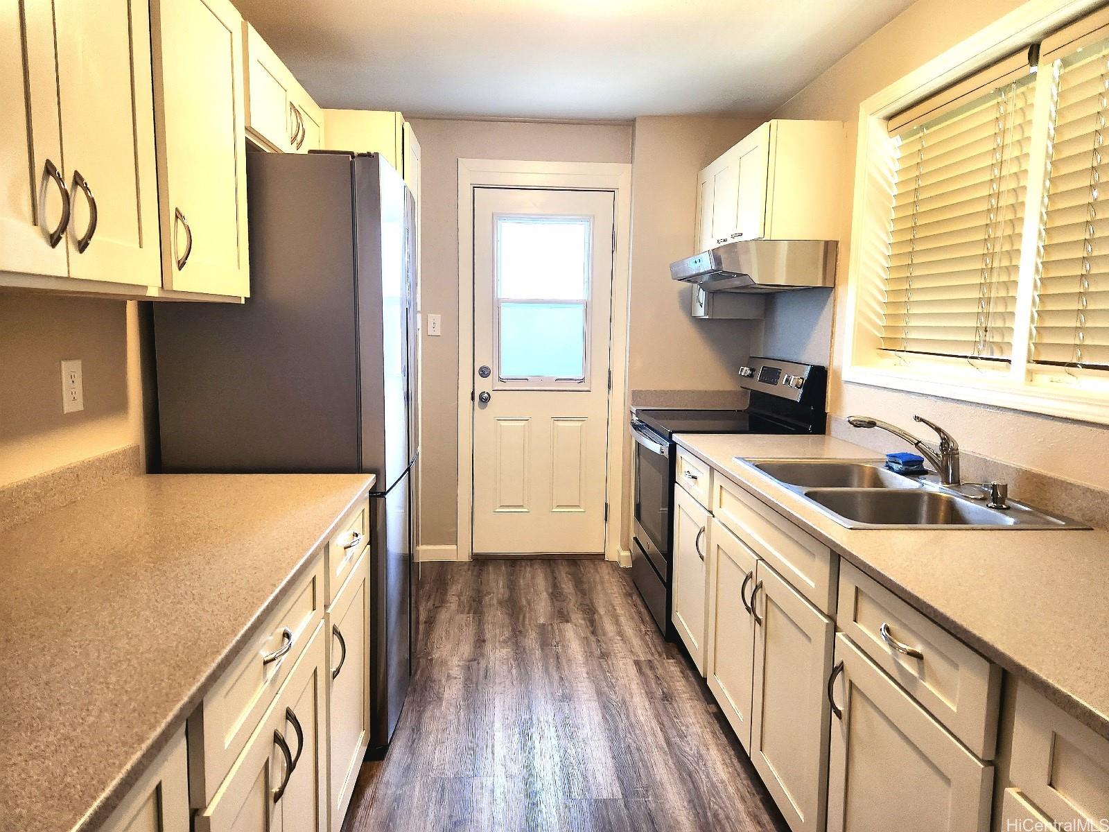 a kitchen with a sink a stove and cabinets